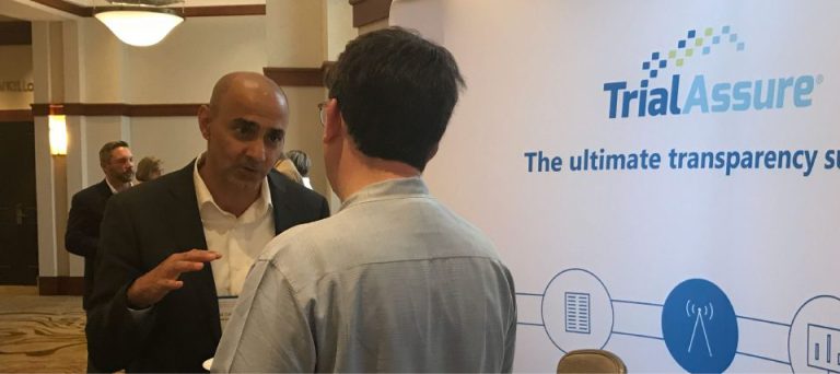 Two people in conversation at a TrialAssure conference booth