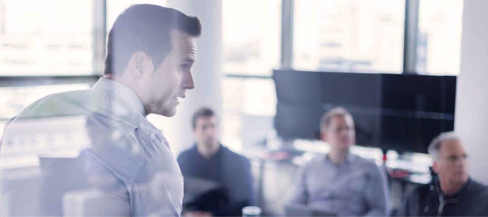 Colleagues in a meeting room during a presentation, tinted blue