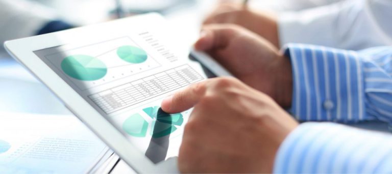 Hands reviewing charts and graphs on a tablet