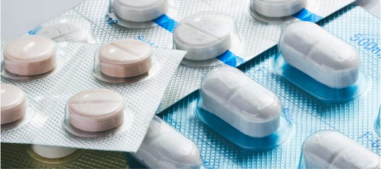 Close-up of white tablets and capsules in blister packaging