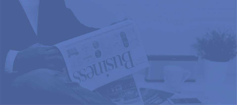 A folded newspaper business section, tinted blue