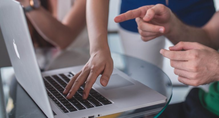 Two colleagues pointing at a laptop screen